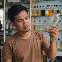 Pemilik toko melihat botol bibit yang hampir habis